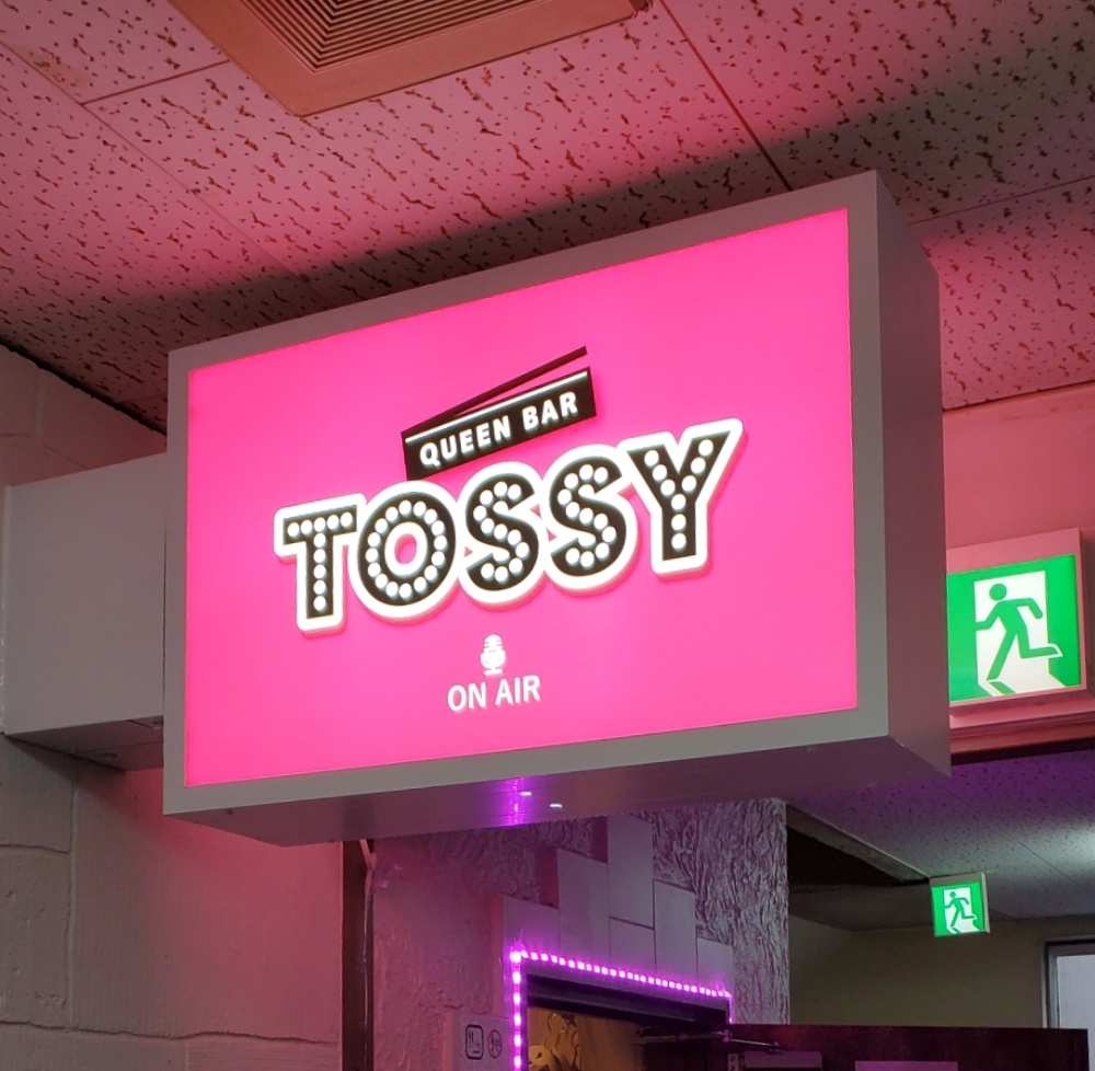 ビル3FにあるTOSSYのピンクの看板